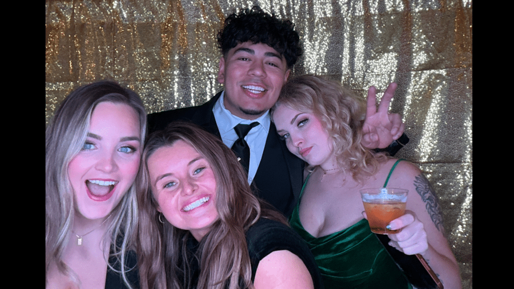 A group of friends posing for the photobooth camera.